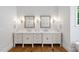 Bathroom featuring a double vanity, decorative mirrors, and sconces at 4404 Yadkin Dr, Raleigh, NC 27609