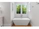 Bright bathroom showcasing a modern freestanding tub and a window view at 4404 Yadkin Dr, Raleigh, NC 27609