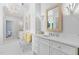 Bright bathroom featuring double vanities, decorative mirror and lighting fixtures, and seating area with yellow pillows at 4404 Yadkin Dr, Raleigh, NC 27609