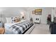 Stylish bedroom with grey upholstered headboard and neutral accents, including a decorative chair and automotive decor at 4404 Yadkin Dr, Raleigh, NC 27609
