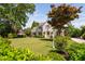 Home's exterior with manicured front lawn, address post, mature trees and professional shrubbery at 4404 Yadkin Dr, Raleigh, NC 27609