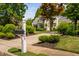 Exterior view of the home's address post, front yard and driveway lined with manicured shrubbery at 4404 Yadkin Dr, Raleigh, NC 27609