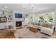 Living room with fireplace, built-in shelving, a white sectional and multiple windows for natural light at 4404 Yadkin Dr, Raleigh, NC 27609