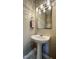 Pedestal sink in the half bath with a decorative mirror and towel at 4725 Parr Vista Ct, Raleigh, NC 27612