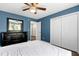 Bedroom with blue walls featuring a ceiling fan, closet, and dark wood furniture at 4725 Parr Vista Ct, Raleigh, NC 27612