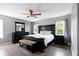 Spacious bedroom with dark wood furniture, ceiling fan, and wood-look flooring at 4725 Parr Vista Ct, Raleigh, NC 27612