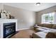Comfortable living room with a cozy fireplace, neutral walls, and natural light from a large window at 4725 Parr Vista Ct, Raleigh, NC 27612
