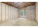 Unfinished basement area with exposed insulation and access to the outside at 4901 Old Elizabeth Rd, Raleigh, NC 27616