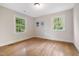 Comfortable bedroom featuring two windows, hardwood floors, and neutral paint offering a peaceful retreat at 4901 Old Elizabeth Rd, Raleigh, NC 27616