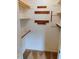Walk-in closet with wooden hanging rods on a beige carpet at 4908 Mandel Rd, Durham, NC 27712