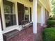 Charming front porch with a bench, flower pot, and red tile at 4908 Mandel Rd, Durham, NC 27712