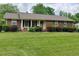 Charming brick home featuring a well-manicured lawn and mature landscaping at 4908 Mandel Rd, Durham, NC 27712