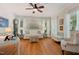 Cozy living room featuring hardwood floors, a ceiling fan, and ample natural light from large windows at 6 Gasper Ct, Durham, NC 27713