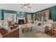Cozy living room with fireplace, ceiling fan, bookshelves, comfortable seating, and natural light from the windows at 6 Gasper Ct, Durham, NC 27713