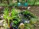 Backyard pond with rocks, flowers, and a bench providing a tranquil, garden retreat at 6 Gasper Ct, Durham, NC 27713