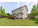 Expansive backyard with a wooden deck, patio, and lush green grass at 6002 Whisperwood Dr, Durham, NC 27713