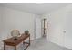 This bedroom has neutral walls and carpet, with a peek at the staircase landing at 6002 Whisperwood Dr, Durham, NC 27713