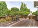 Wood deck with a table and two chairs surrounded by a wooded backyard at 6002 Whisperwood Dr, Durham, NC 27713