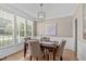 Elegant dining room featuring hardwood floors, modern chandelier, and wainscoting detail, flooded with natural light at 6002 Whisperwood Dr, Durham, NC 27713