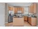 Functional kitchen features stainless steel appliances, wooden cabinets, and a central island at 6002 Whisperwood Dr, Durham, NC 27713