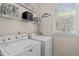 Convenient laundry area with modern appliances, storage shelves, and a bright window at 6002 Whisperwood Dr, Durham, NC 27713