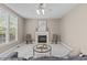 Inviting living room featuring plush carpet, a fireplace, and large windows offering ample natural light at 6002 Whisperwood Dr, Durham, NC 27713
