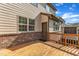A covered back porch features a wooden railing and brick foundation with a view of the backyard at 644 Angelica Cir, Cary, NC 27518