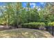 A backyard with a lawn is bordered by a black fence and trees at 644 Angelica Cir, Cary, NC 27518