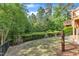 Lush backyard with mature trees, a black metal fence, offering privacy and a serene outdoor space at 644 Angelica Cir, Cary, NC 27518