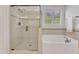 Bright bathroom features a glass enclosed shower and separate soaking tub near window at 644 Angelica Cir, Cary, NC 27518