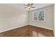 Bright bedroom with hardwood floors, ceiling fan, and a large window with backyard view at 644 Angelica Cir, Cary, NC 27518