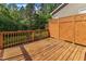 Wooden deck with a partial privacy screen overlooking a green, tree-filled backyard at 644 Angelica Cir, Cary, NC 27518