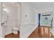 Hallway featuring hardwood floors, wainscoting, and a half-bathroom at 644 Angelica Cir, Cary, NC 27518