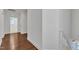 Hallway with white walls, hardwood floors, and a staircase leading to the upper level at 644 Angelica Cir, Cary, NC 27518
