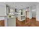 Gorgeous kitchen featuring white cabinets, granite countertops, stainless appliances, and a central island at 644 Angelica Cir, Cary, NC 27518