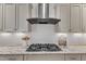Close-up view of a stainless steel gas range stove top with granite countertops and white subway tile backsplash at 644 Angelica Cir, Cary, NC 27518