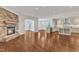 Open-concept living space with hardwood floors, stone fireplace, and modern kitchen at 644 Angelica Cir, Cary, NC 27518