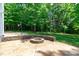 A backyard view featuring a stone firepit and basketball hoop at 6509 Duncans Creek Ct, Fuquay Varina, NC 27526