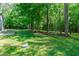 Backyard with mature trees, garden beds, and playground equipment at 6509 Duncans Creek Ct, Fuquay Varina, NC 27526