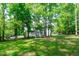 A partial exterior view with backyard, showing the mature trees and lush grass at 6509 Duncans Creek Ct, Fuquay Varina, NC 27526