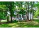 A partial exterior view with backyard, showing the mature trees and lush grass at 6509 Duncans Creek Ct, Fuquay Varina, NC 27526