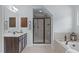 A bathroom featuring a tub, glass shower, and elegant vanity at 6509 Duncans Creek Ct, Fuquay Varina, NC 27526