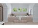 Bathroom featuring a large soaking tub beneath bright windows at 6509 Duncans Creek Ct, Fuquay Varina, NC 27526