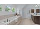 Well-lit bathroom features a soaking tub and wooden cabinets at 6509 Duncans Creek Ct, Fuquay Varina, NC 27526