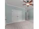 This bedroom features neutral carpeting, a ceiling fan, and double doors at 6509 Duncans Creek Ct, Fuquay Varina, NC 27526