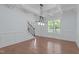 Formal dining room with coffered ceiling, hardwood floors, and modern chandelier next to the staircase at 6509 Duncans Creek Ct, Fuquay Varina, NC 27526