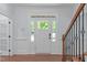 Bright foyer featuring hardwood floors, white wainscoting, and a staircase with black iron spindles at 6509 Duncans Creek Ct, Fuquay Varina, NC 27526