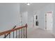 Bright upstairs hallway with carpet and three open doors at 6509 Duncans Creek Ct, Fuquay Varina, NC 27526