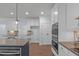 Bright kitchen featuring stainless steel appliances, granite countertops, an island, and white cabinets at 6509 Duncans Creek Ct, Fuquay Varina, NC 27526