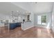 Open-concept kitchen with stainless steel appliances and an island breakfast bar open to a living space at 6509 Duncans Creek Ct, Fuquay Varina, NC 27526